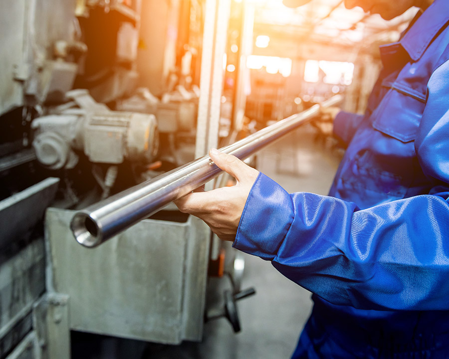 Worker checking metal pipes at a metallurgical plant Worker checking metal pipes at a metallurgical plant.
